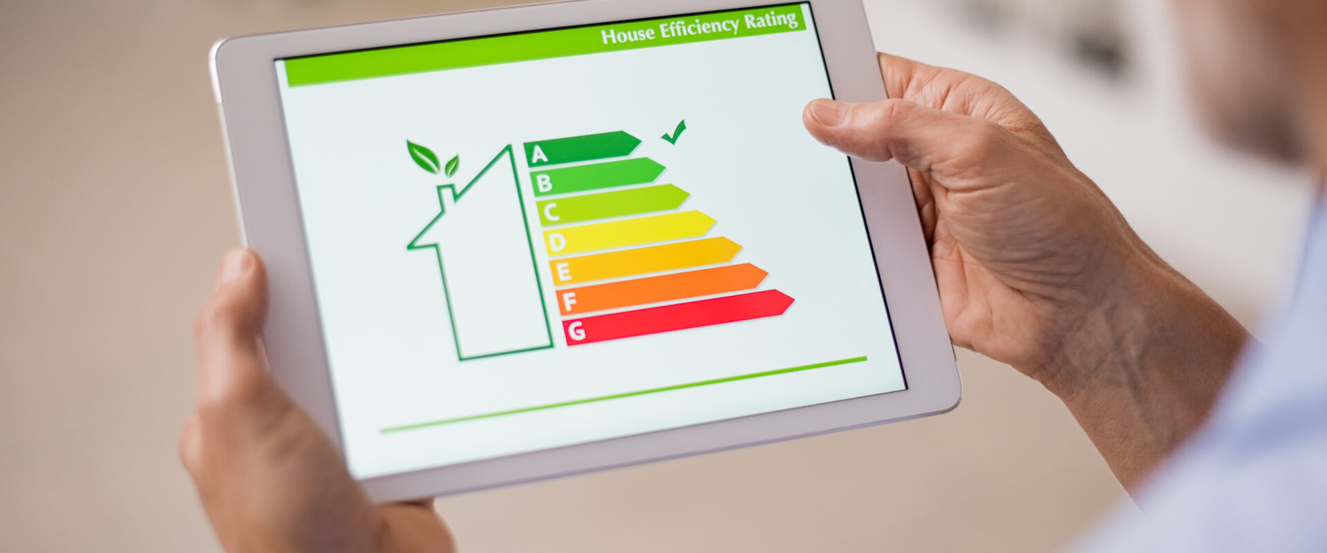 Hand,Holding,Digital,Tablet,And,Looking,At,House,Efficiency,Rating.